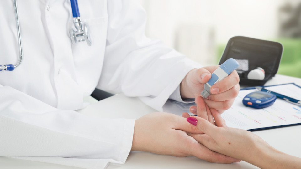 Eine Patientin mit Diabetes misst beim Arzt ihren Blutzuckerspiegel