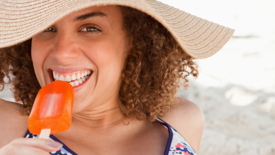 Eine Frau ist ein Eis am Strand im Urlaub